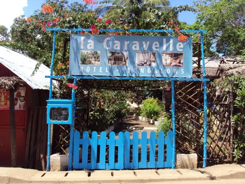 Portail bleu et enseigne « La Caravelle, hôtel & bungalows »